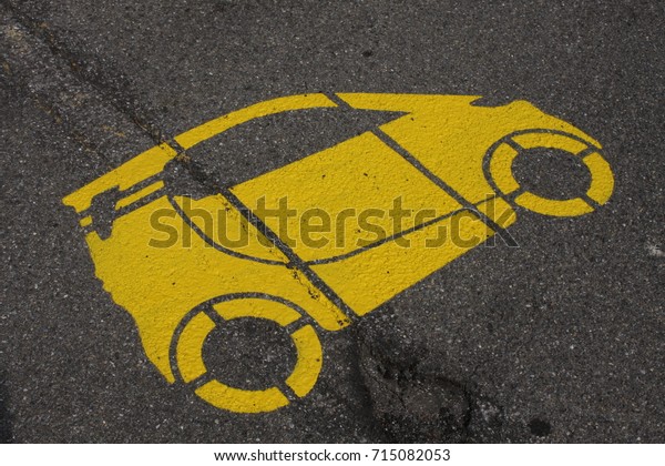 parking spot with a\
yellow car painted.