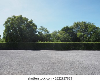 Parking lot sprinkled with gravel bush green tree blue sky nature background - Shutterstock ID 1822927883