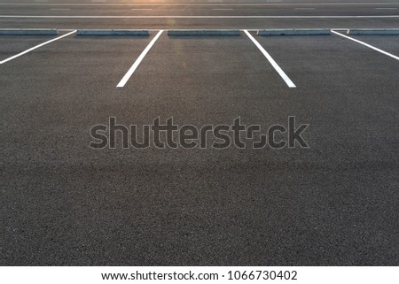 Parking stalls in a parking lot, marked with white lines. Empty parking lot background with copy writing space.