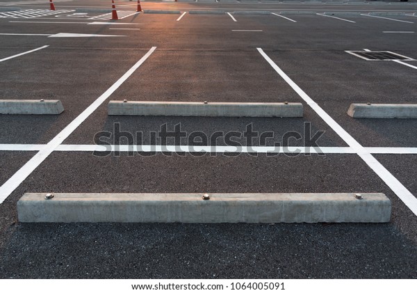Parking stalls in a\
parking lot, marked with white lines. Empty parking lot background\
with copy writing\
space.