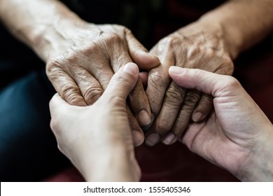 Parkinson And Alzheimer Female Senior Elderly Patient With Caregiver In Hospice Care. Doctor Hand With Stethoscope Check Up Older Woman People. Old Aging Person Seeing Medical Physician In Hospital.