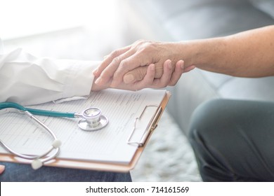 Parkinson And Alzheimer Female Senior Elderly Patient With Caregiver In Hospice Care. Old Woman Holding Hand With Doctor Physician Or Specialized Assistance.