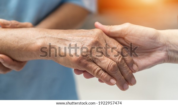 Parkinson disease patient, Alzheimer elderly\
senior, Arthritis person\'s hand in support of nursing family\
caregiver care for disability awareness day, National care givers\
month, aging society\
concept