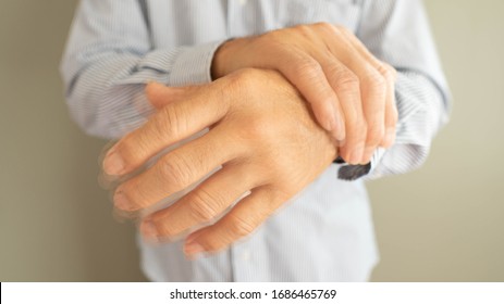 Parkinson's disease symptoms. Close up of tremor (shaking) hands of senior man patient with Parkinson's disease. Mental health and neurological disorders concept.