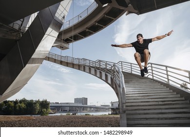 Parkour athlete doing a beautiful high jump from the stairs. Man performing his freerun skill. - Powered by Shutterstock