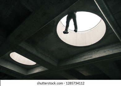 Parkour Athlete Hanging From A Edge Of A Rooftop Hole