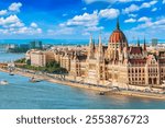 Parliament and Danube riverside in Budapest Hungary with sightseeing ship during summer sunny day with blue sky and clouds