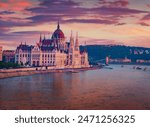 Parliament house on the shore of Dunabe river. Stunning summer cityscape of Budapest. Colorful sunset in Hungary, Europe. Traveling concept background.
