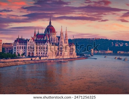 Parliament house on the shore of Dunabe river. Stunning summer cityscape of Budapest. Colorful sunset in Hungary, Europe. Traveling concept background.