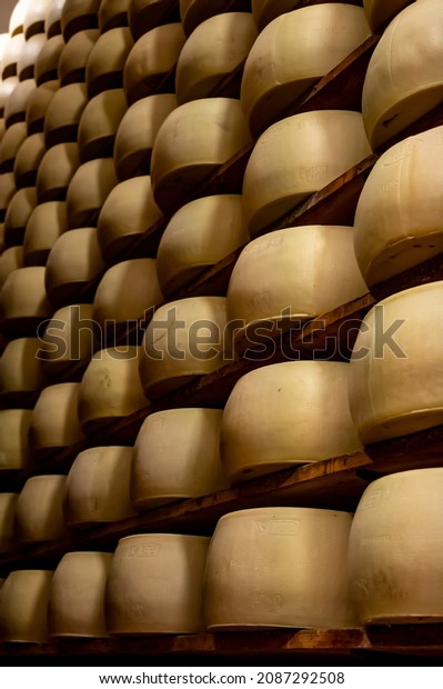 Parma, Italy, October 29, 2021. Process of making\
parmigiano-reggiano parmesan hard cheese on small cheese farm in\
Parma, Italy, factory maturation room for aging of cheese wheels up\
to 5 years