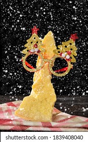 Parmesan Cheese With Christmas Glasses And The Black Background, And Falling Snowflakes