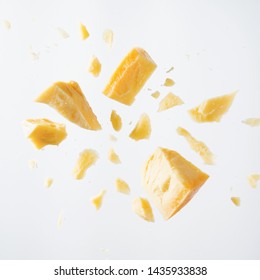 Parmesan cheese flying in different directions with crumbs on a white background with space for the text.  - Shutterstock ID 1435933838