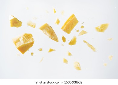 Parmesan Cheese Flying In Different Directions With Crumbs On A White Background With Space For The Text. 