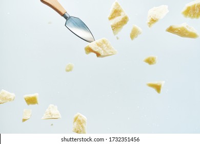 Parmesan Cheese Flying In Different Directions With Crumbs Isolated On A White Background. 