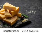 Parmesan cheese on a wooden board, Hard cheese on a dark background. banner, menu, recipe place for text, top view.