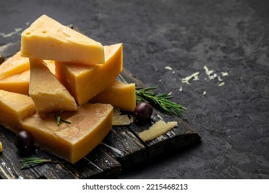 Parmesan cheese on a wooden board, Hard cheese on a dark background. banner, menu, recipe place for text, top view. - Shutterstock ID 2215468213