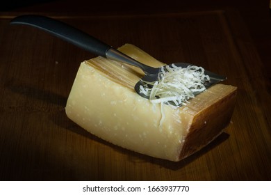 Parmesan Cheese In The Process Of Being Graded On A Wooden Board