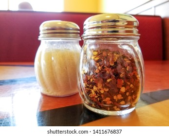 Parmesan Cheese And Red Pepper Flakes Shakers In An Italian Restaurant 