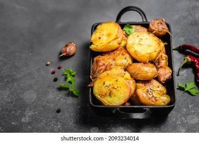 Parmesan Pesto Roast Potatoes In Cast Iron Skillet On Dark Background. Top View, Copy Space.