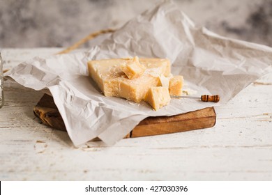 Parmesan Reggiano Cheese And Wax Paper. Rustic Style.