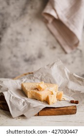 Parmesan Reggiano Cheese And Wax Paper. Rustic Style.