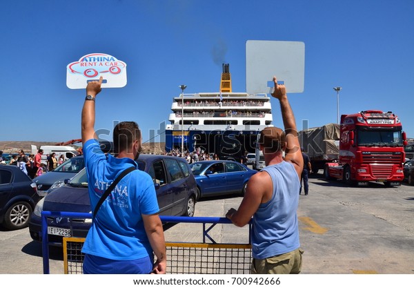 PAROS PORT, PAROS ISLAND,\
GREECE - Hotel and car rental agency representatives hold up their\
signs as tourists disembark from a ferry at Paros Island\'s\
port