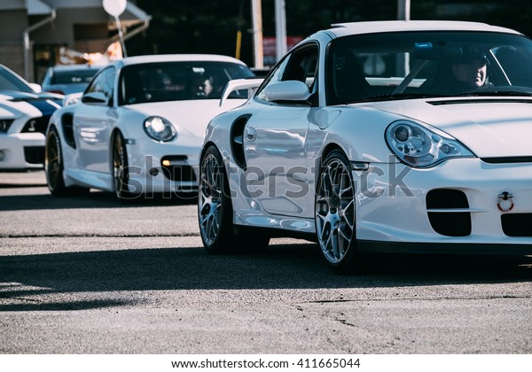 Parsippany,NJ - April 24th 2016: At a free car\
show, a couple of modern Porsches pull\
in.