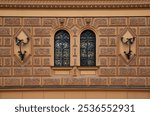 Part of an ancient building, a wall with windows, arched windows protected by wrought iron ornate grilles, the beauty of ancient architecture