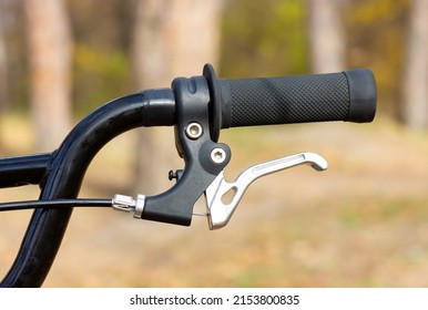 Part of a bicycle handlebar. Hand brakes on a bicycle handlebar.