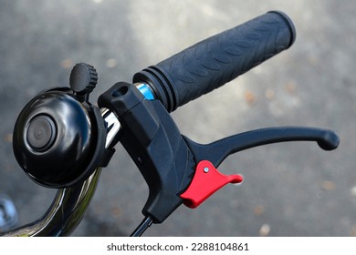 Part of a bicycle handlebar with handbrake and bell. Close up. - Powered by Shutterstock