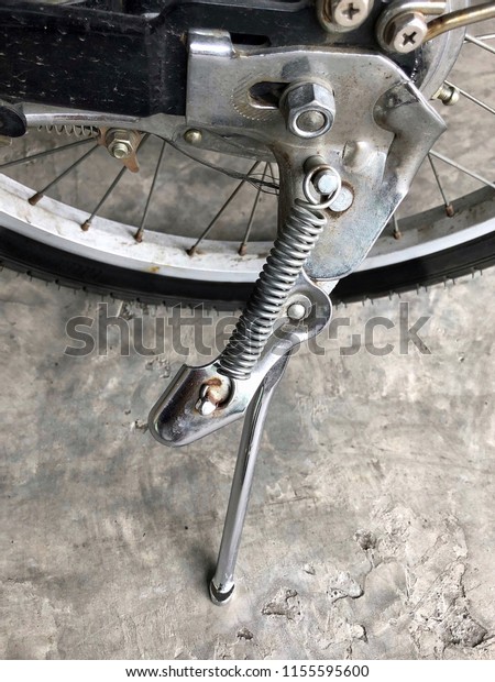 Part of bicycle, stand break and wheel on concrete\
stone floor