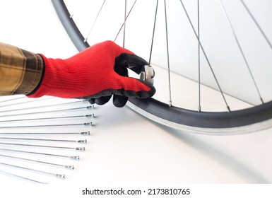 part of a bicycle wheel, adjusting the spokes of the wheel with a tool, close-up, on an isolated white background