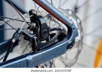 Part of the bicycle's braking system. Grey metal brake disc and brake pads on road bike, close up. - Powered by Shutterstock