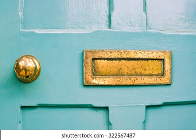 Part of a blue front door with a weathered metal letterbox