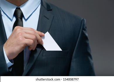 Part of body of business man who takes out business card from the pocket of business suit, copyspace - Powered by Shutterstock