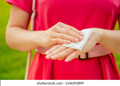 Part Of The Body Of A Young Woman In A Pink Park . Girl Using Wet Wipes The Sweat