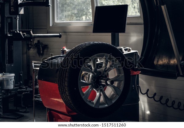 Part of broken car with wheel and tyre is waiting\
to be fixed.