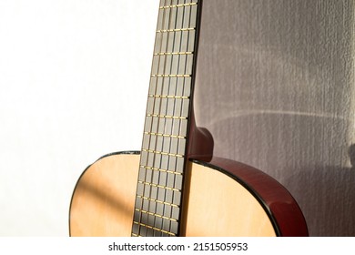 A part of brown wooden classic guitar. Six strings