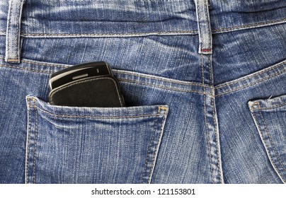 Part of cellphone in the back pocket of blue jeans