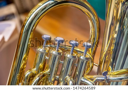 A part of the classical wind instrument with brass details. Close up of trumpet finger buttons valves