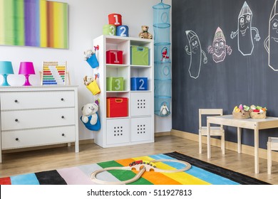 Part Of Colorful Child Room With Cabinet, Chest Of Drawers And Table For A Child