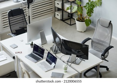Part of contemporary open space bureau of diversity programming with computer monitors and two laptops on desks - Shutterstock ID 2120006555