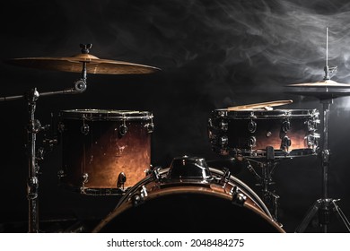 Part of a drum kit against a black background, percussion instrument, snare drum, bass drum, hi-hat on stage under the spotlights.