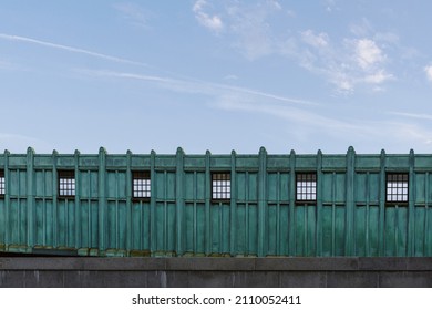 Part Of Elevated Station In Boston. Green Metal Wall Exterior Of A Train Platform