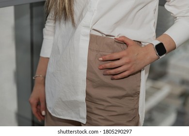 Part female body and white shirt   beige pants  new gradient manicure hands and clock  Trendy manicure concept  Female hands and beautiful brown nail polish  Nail art manicure