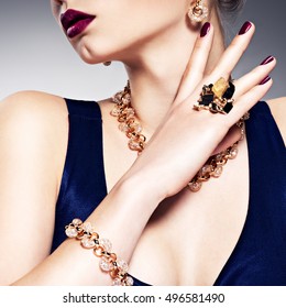 Part of female face with beautiful golden jewelry on body and bright make-up -  posing at studio 