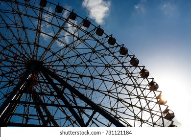 Part of ferris wheel silhouette during sunset.