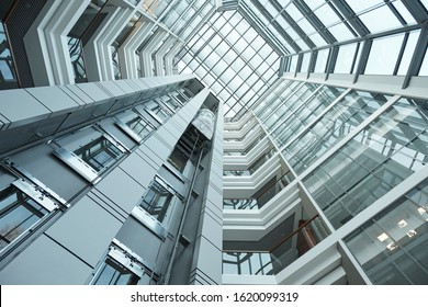 Part of interior of contemporary tall office building with moving elevator that can be used as background