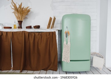 part of the kitchen interior with a table and an old green vintage refrigerator