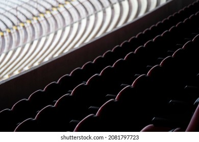 Part Of A Large, Empty Auditorium At A Public Venue, With Lots Of Chairs In Different Colors